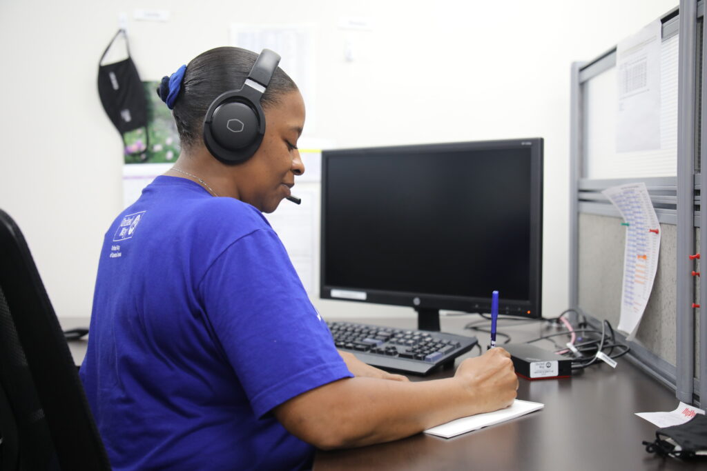 Woman with headset writing notes