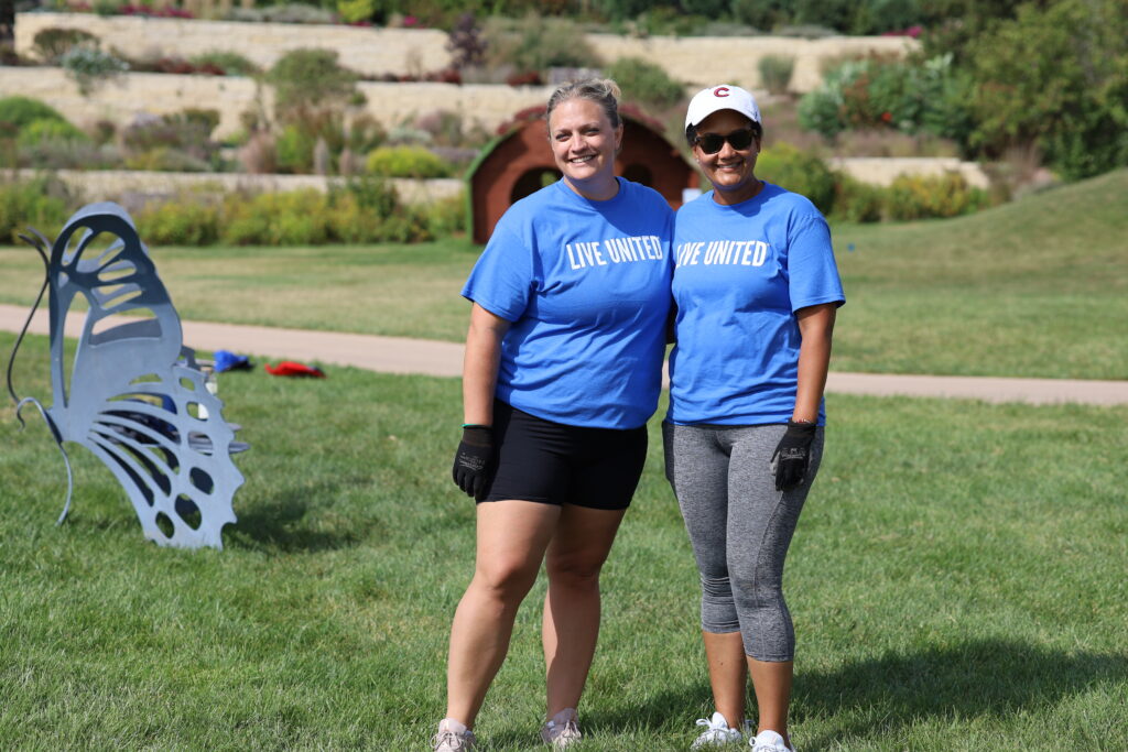 Two women in blue shirts smiling