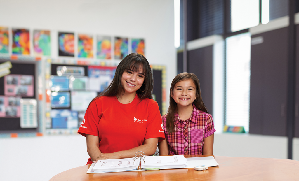 Two girls smiling at a table.