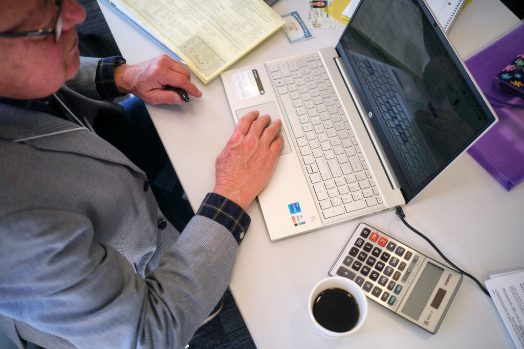 Person working with laptop and calculator