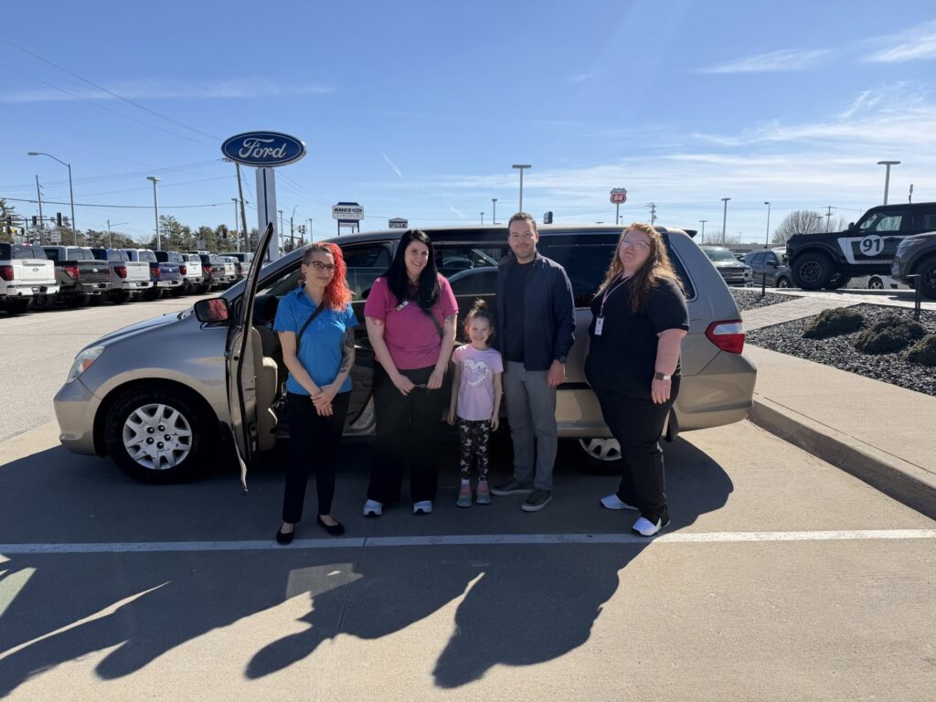 Group by a car outside dealership