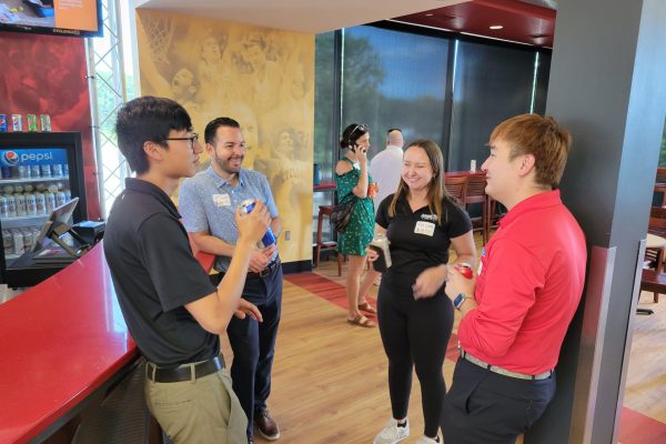 Group of people chatting indoors.