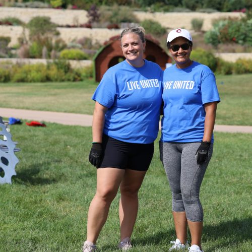 Two women in blue shirts smiling