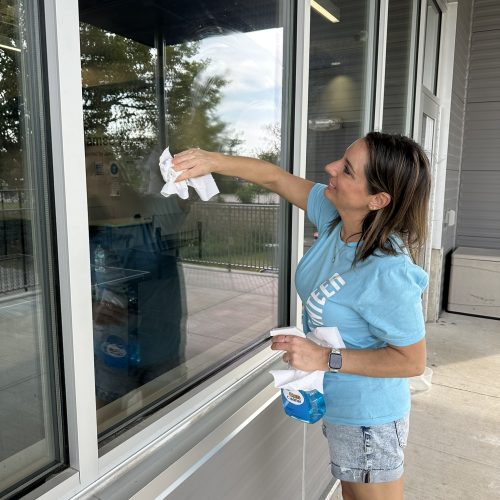 Woman cleaning a large window.