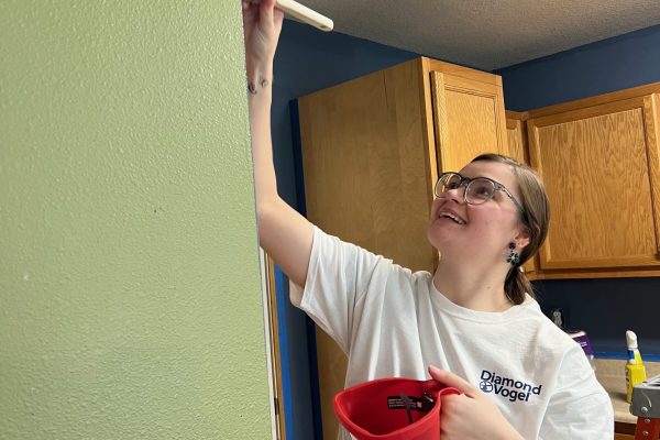 Person painting a wall indoors.