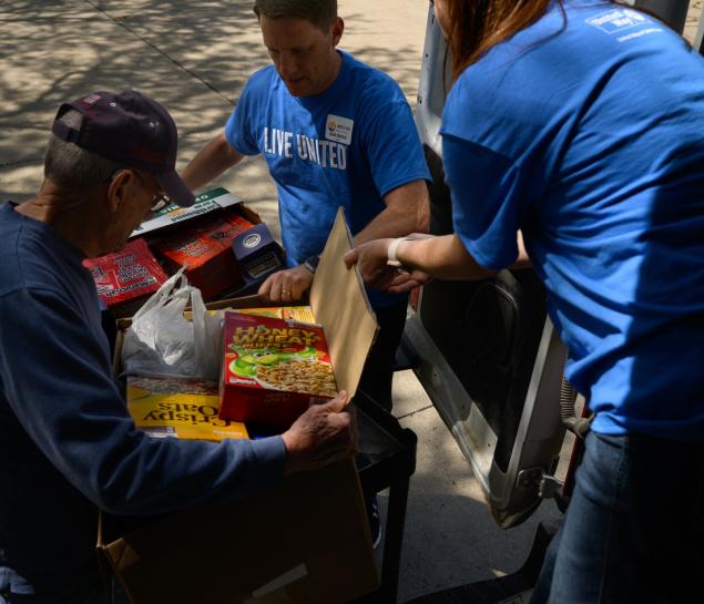 People delivering food items to a local pantry